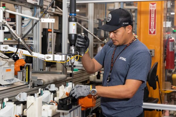 Factory worker works at machine