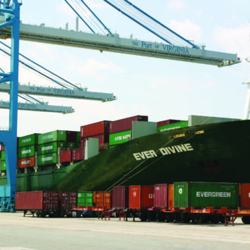 View of a freight ship at harbor with loading cranes